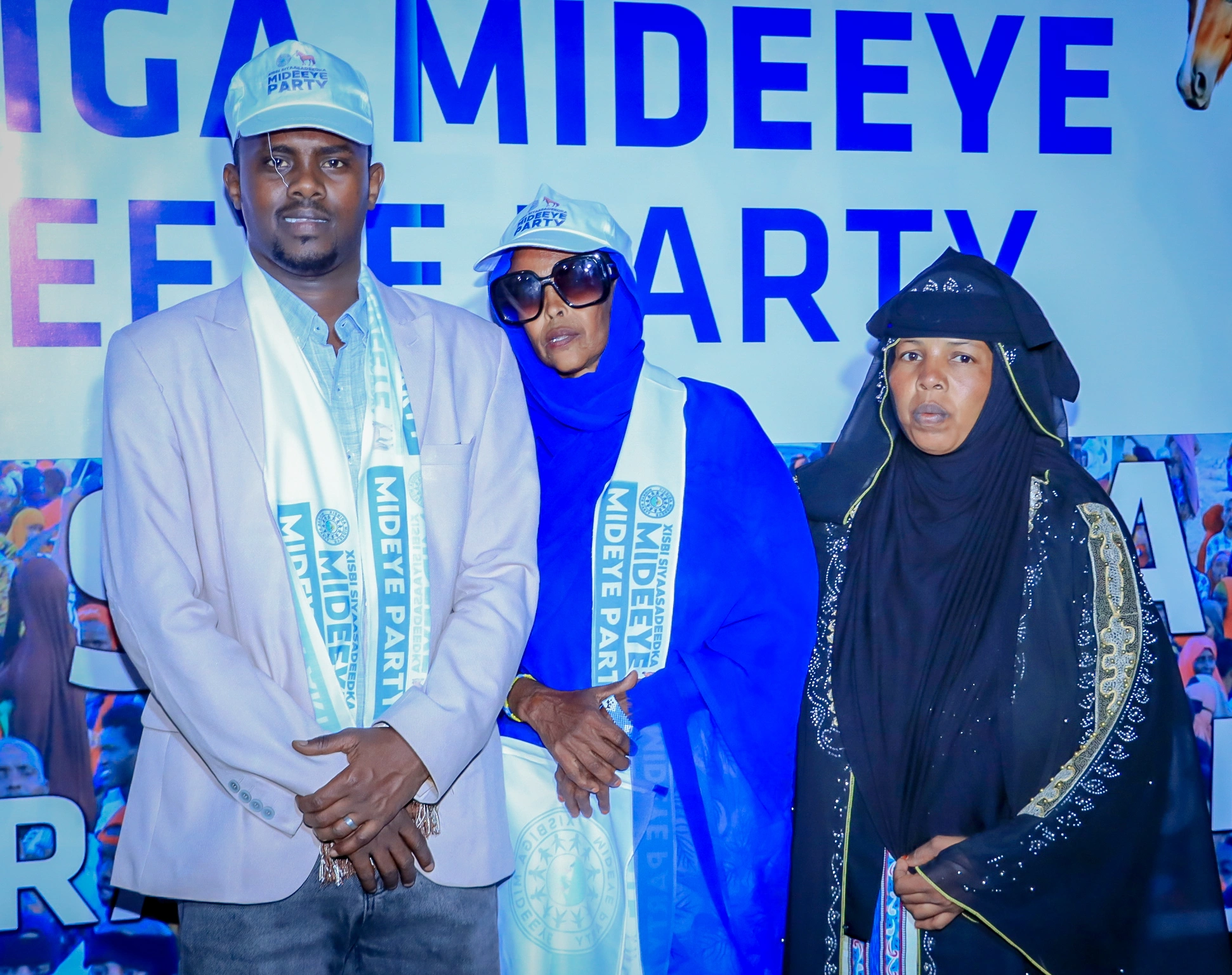 Mideeye party supporters standing in front of a Mideeye backdrop